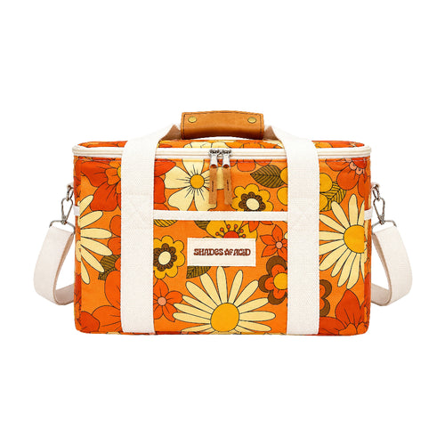 An orange daisy-patterned cooler bag with white straps, a brown leather handle, and a silver zipper, shown on a plain white background.