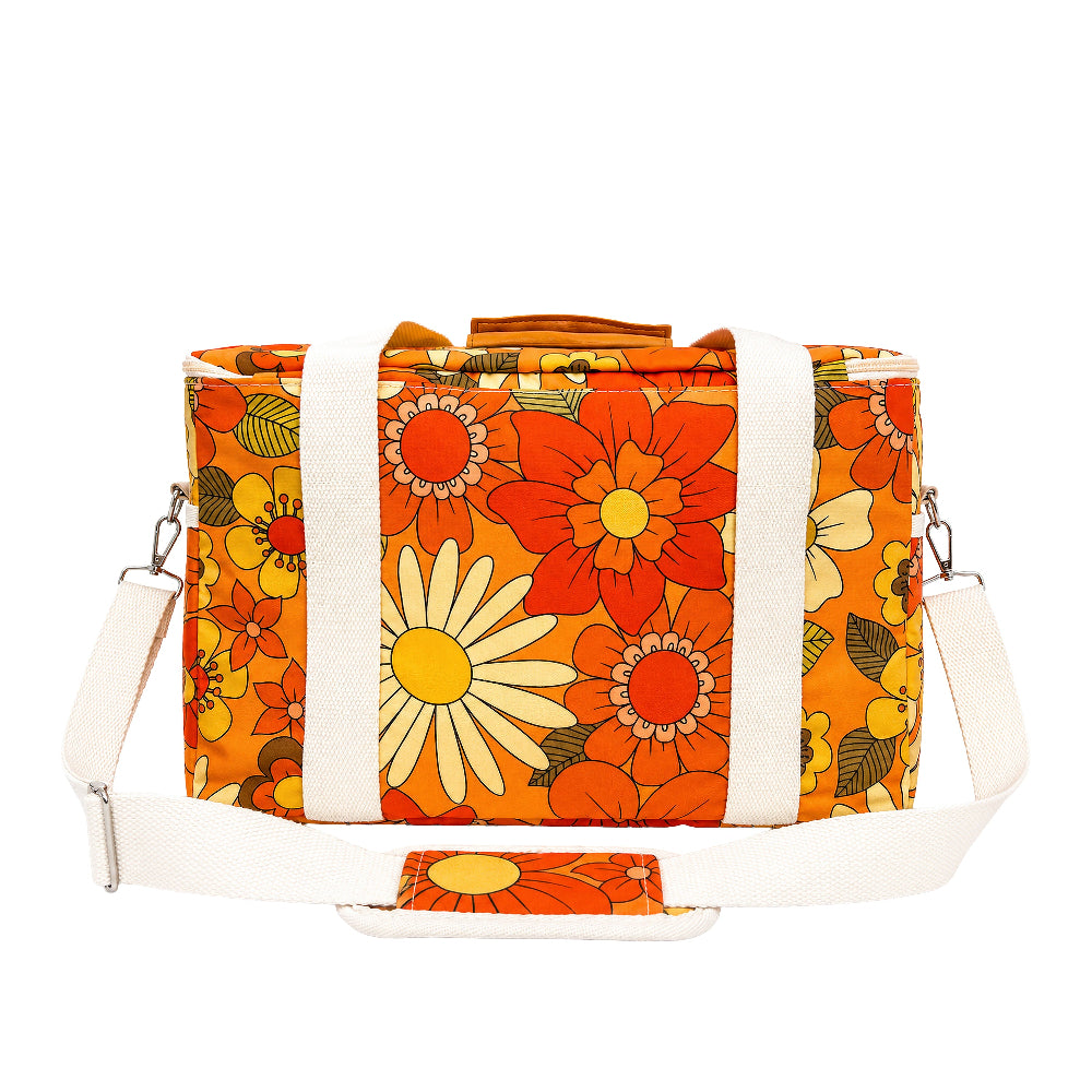 A retro-style duffel bag with a vibrant orange and yellow floral print, featuring thick white canvas side straps and a matching adjustable shoulder strap.