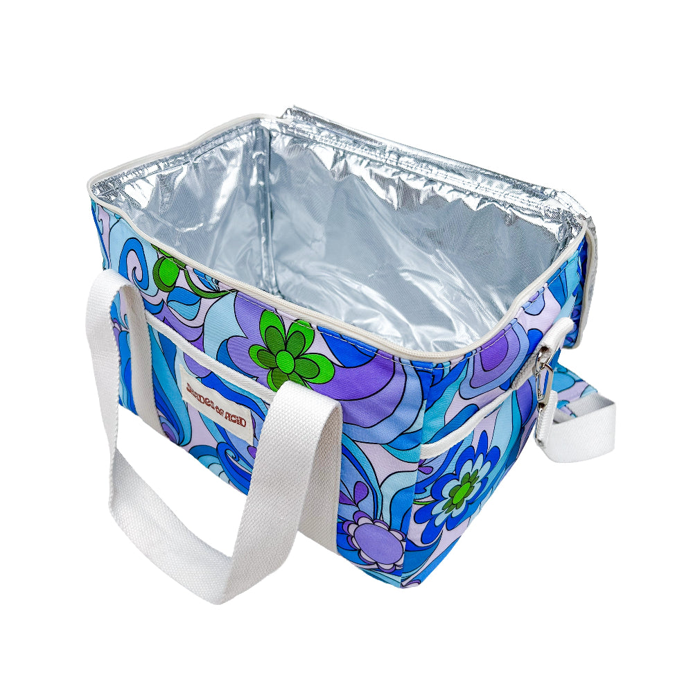 A square cooler bag with a retro 70s-style floral pattern in blue, purple, and green, featuring a silver foil-lined interior and white webbing handles.