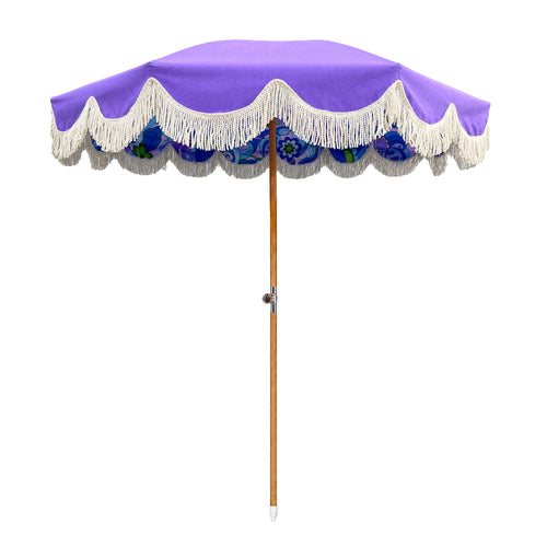 A purple patio umbrella with white fringe trim and a blue floral patterned underside, shown on a plain white background.