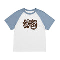 A raglan-style short-sleeve t-shirt with a white body and light blue sleeves, featuring a distressed brown graphic on the chest that reads 'Shades of Acid'.